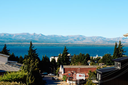 street leading to the shore of the lake with buildings among the trees against the backdrop of the lake and mountainsの写真素材