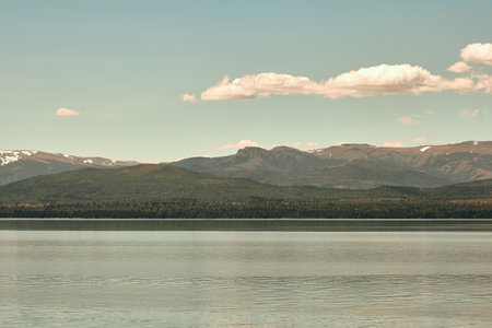 Beautiful landscape of a lake against a backdrop of mountains under a clear blue sky. Rocky mountains, turquoise lake, white clouds.の写真素材