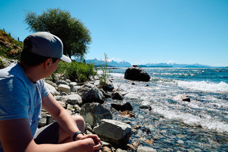Traveling young man on a beautiful sunny day on the shore of a lake. Argentina. Patagonia