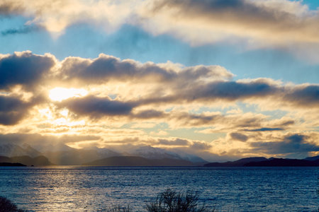 Evening sky with dramatic clouds over mountains, lake and trees. Dramatic sunset over the lakeの写真素材