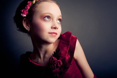Young model in red dress posing on black backgroundの写真素材