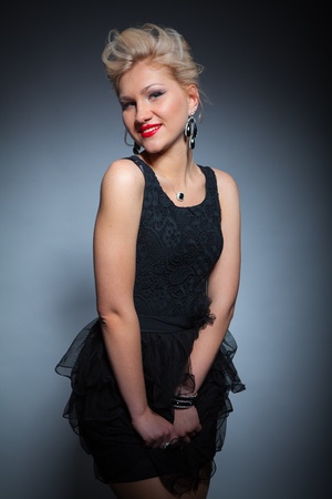 beautiful women in black dress posing on dark backgroundの写真素材