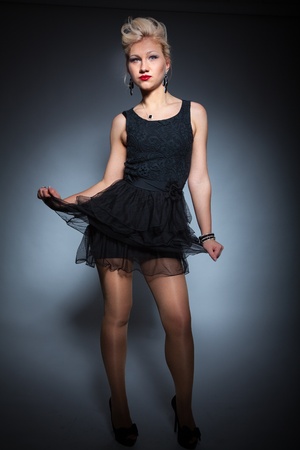 beautiful women in black dress posing on dark backgroundの写真素材