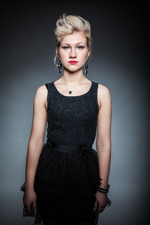 beautiful women in black dress posing on dark backgroundの写真素材