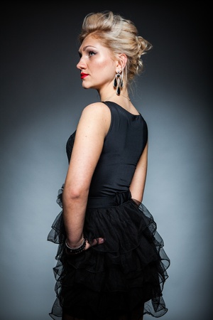 beautiful women in black dress posing on dark backgroundの写真素材