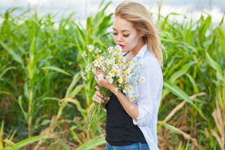 asian women with bouquet of camomillesの写真素材