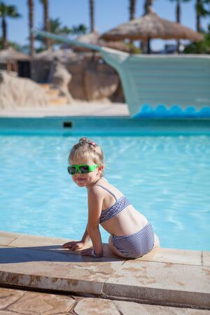 pretty yound child sit on swimming poolの写真素材