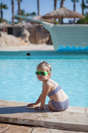 pretty yound child sit on swimming poolの写真素材