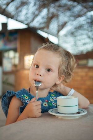 pretty little girl drinking tea from a cupの写真素材