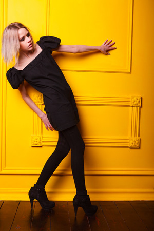 Lean beauty girl posing on yellow backgroundの写真素材