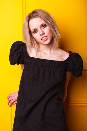 Portrait of pretty lean girl on yellow backgroundの写真素材
