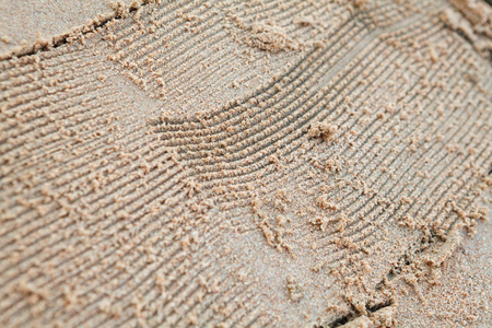 scratching waves on yellow sea sandの写真素材