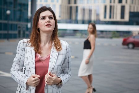 Young beautiful woman in checkered jaket on her girlfriend backgroundの写真素材