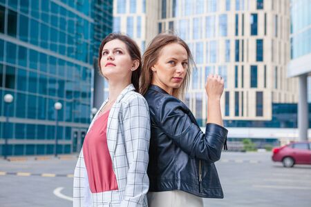 Young beautiful girlfriends posing on city backgroundの写真素材
