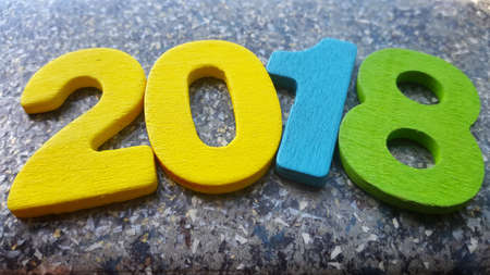 Wooden numbers forming the number 2018, For the new year 2018 on a abstract backgroundの写真素材