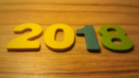 Wooden olored numbers forming the number 2018, For the new year 2018 on a wooden background.の写真素材