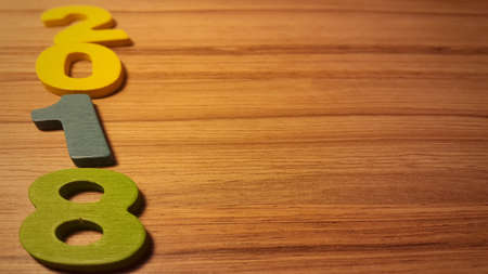 Wooden olored numbers forming the number 2018, For the new year 2018 on a wooden background.の写真素材