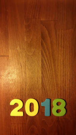 Wooden olored numbers forming the number 2018, For the new year 2018 on a wooden background.の写真素材