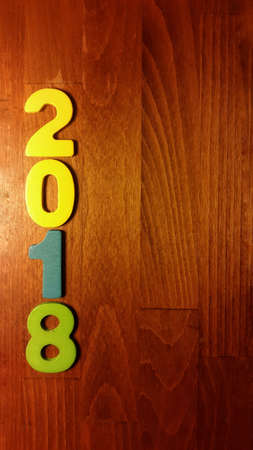 Wooden olored numbers forming the number 2018, For the new year 2018 on a wooden background.の写真素材
