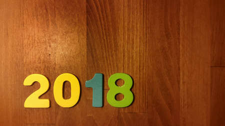 Wooden olored numbers forming the number 2018, For the new year 2018 on a wooden backgroundの写真素材