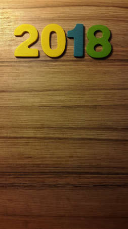 Wooden olored numbers forming the number 2018, For the new year 2018 on a wooden backgroundの写真素材