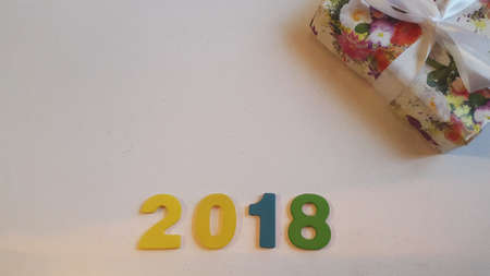 Colored figures to form the number 2018 on white canvas with Christmas gifts.の写真素材