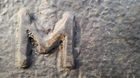 Metal latter M. Texture of rusty metal in the form of latter M.の写真素材