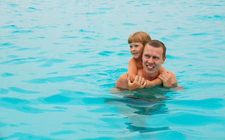 The happy child swimming with the father in the tropical resort in the sea. Concept of summer vacations.の写真素材