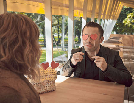 Loving couple at restaurant with red heart - St.Valentines Day concept