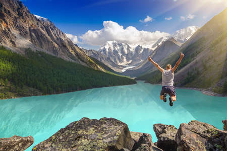 Beautiful mountain landscape with lake and jumping man Beautiful mountain landscape with lake and jumping man