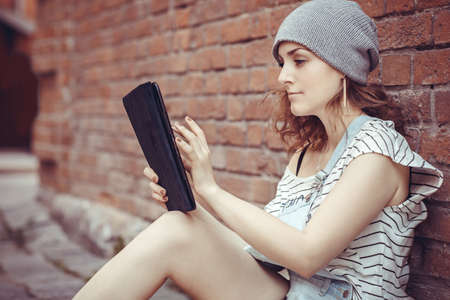 Beautiful hipster young girl works on the tablet on the internetの写真素材