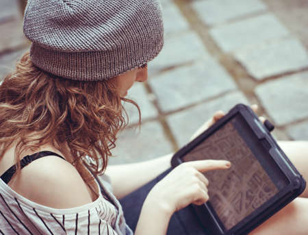 Hipster girl holding tablet with gps, using map appの写真素材