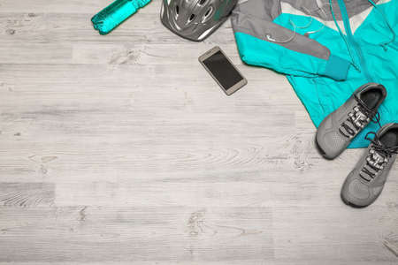 Fitness concept with mobile phone with earphones and sport footwear over wooden background. Top view.の写真素材