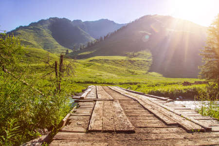 Sunrise mountain landscape with wooden bridge