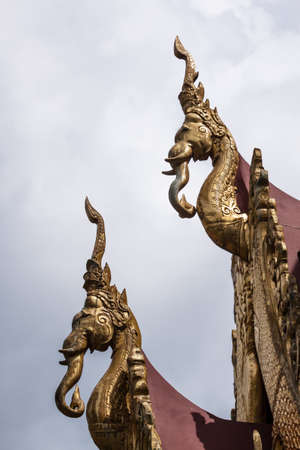 The elongated and elaborately carved apex of the gable of a Buddhist templeの写真素材