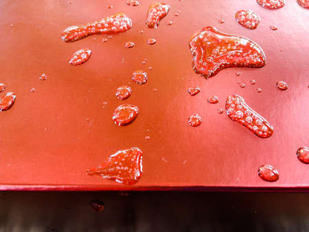 Water droplets on a red background.の写真素材