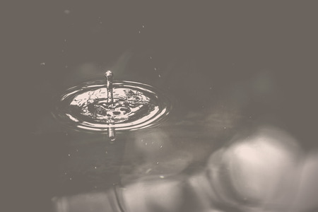 Drop impact wave surface is small. Vintage picture style.の写真素材