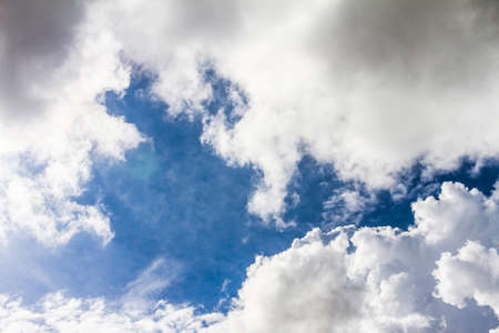 Fluffy white clouds and blue sky before rain will fall background.