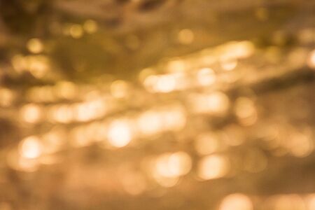 Abstract background bokeh a gold, light reflected from the water. focus lens blur.の写真素材