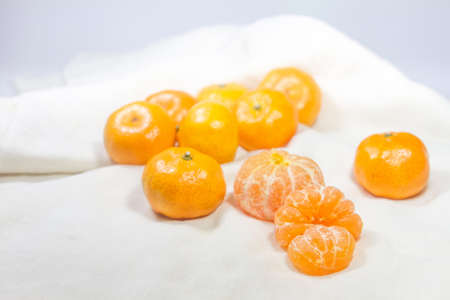 The fresh oranges are arranged on a white cloth background.の写真素材