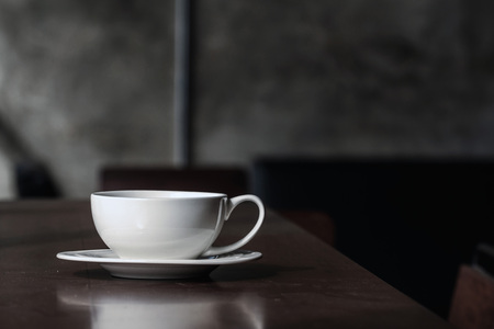 A glass of coffee, served on a wood desk.の写真素材