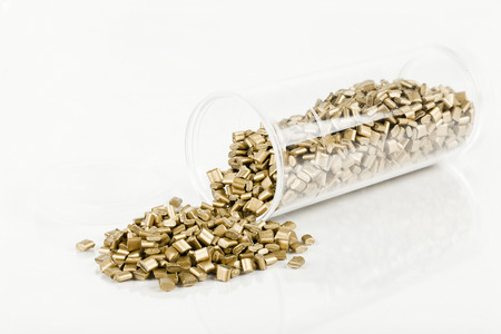 gold plastic granules on white background