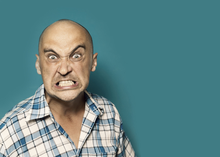 very angry portrait og men on blue backgroundの写真素材