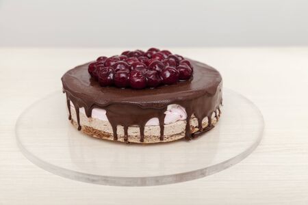 chocolate cake with cherries on wooden table