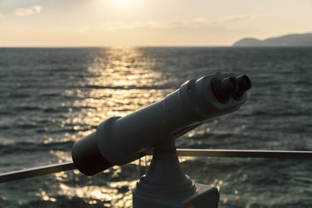 binoculars against the sunset at seaの写真素材