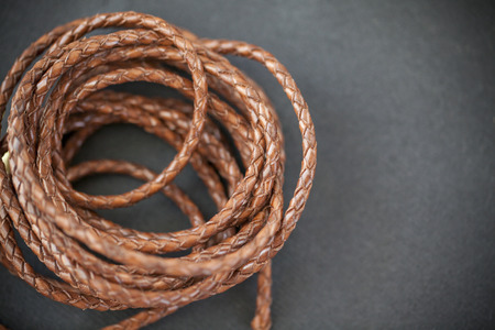 leather braids on black background, close up