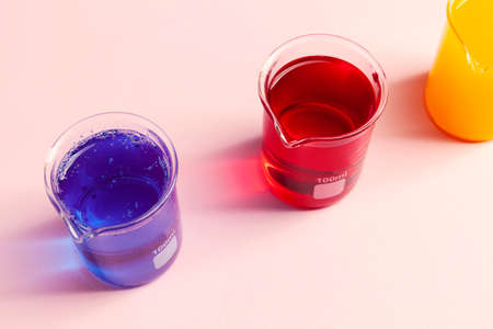 a glass vessel for a chemical laboratory with a blue and red liquid, close upの写真素材