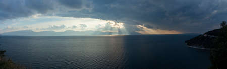 sunset before a storm at sea, the sun's rays break through the clouds