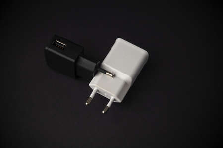 black and white mobile phone charger against each other, close up