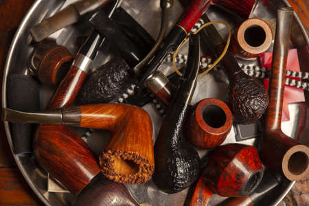 many wooden pipes for smoking tobacco on the pile, close upの写真素材